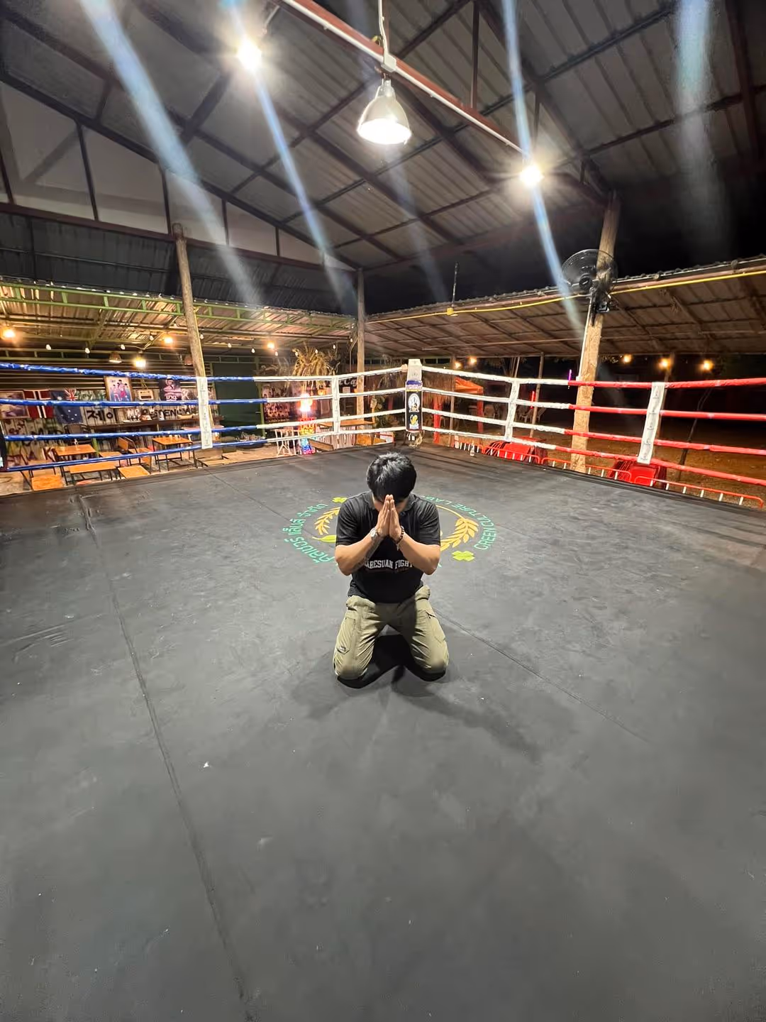 Jay, gym owner, kneeling inside the boxing ring