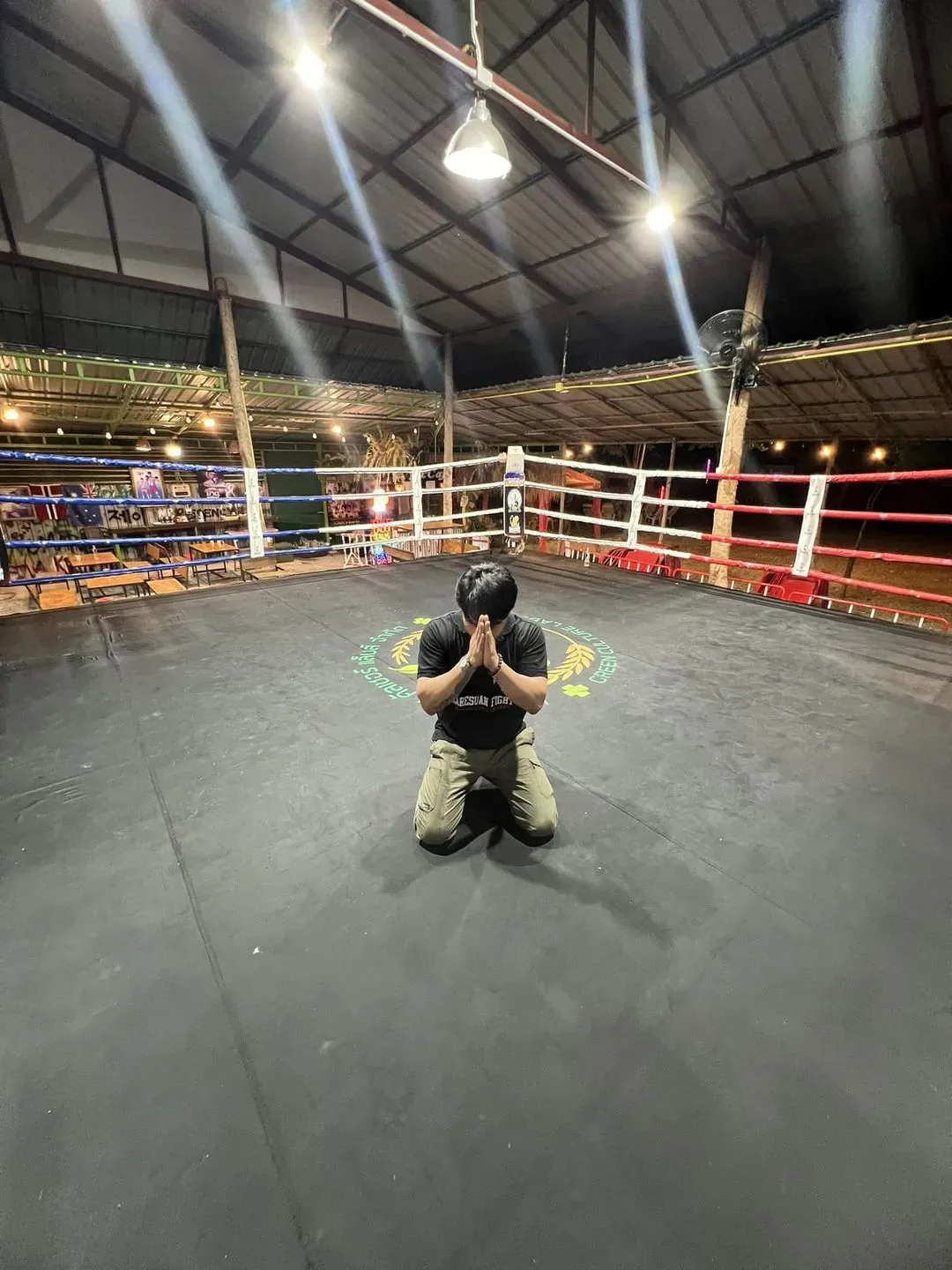 Jay, gym owner, kneeling inside the boxing ring