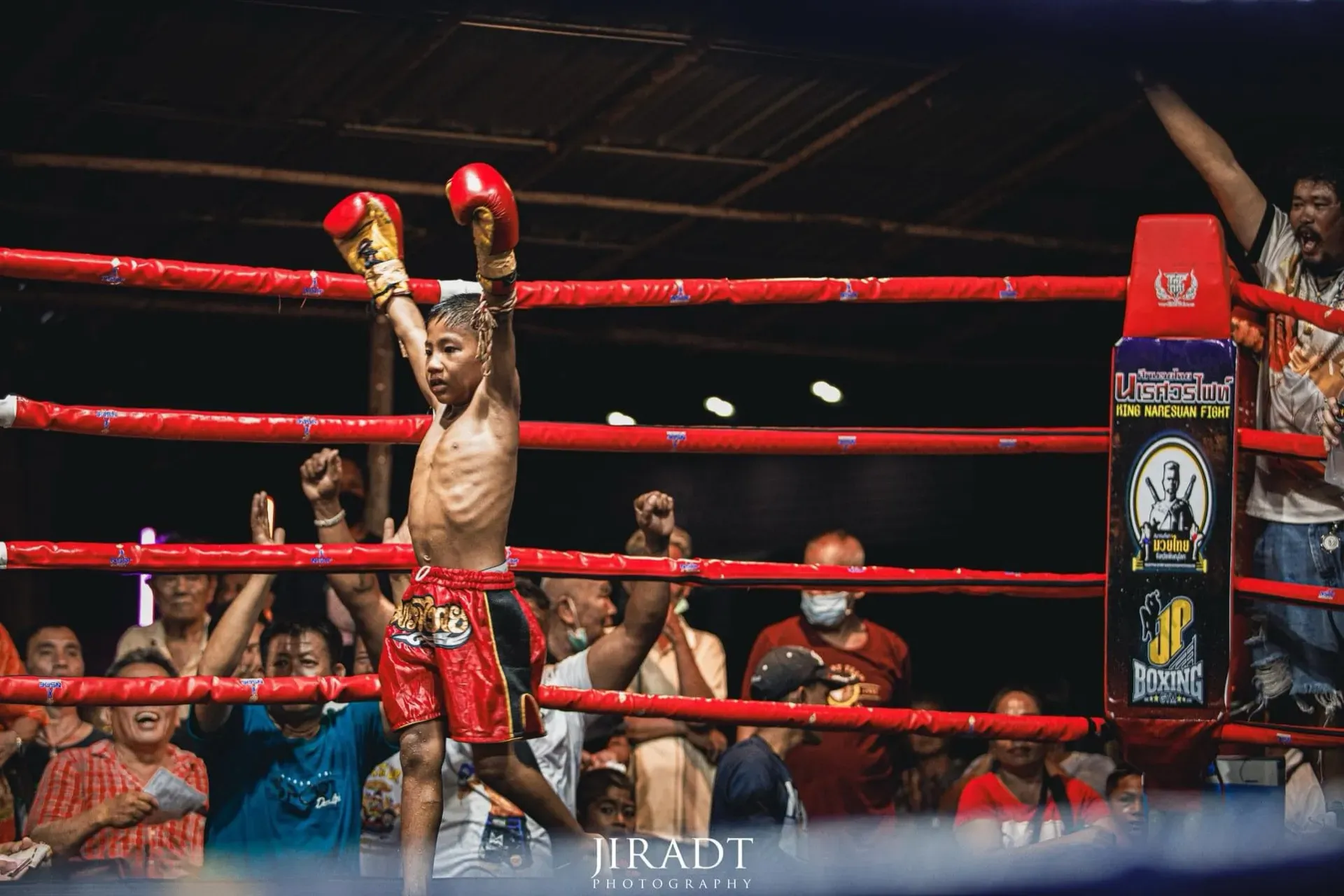 Young Muay Thai winner celebrating in red shorts