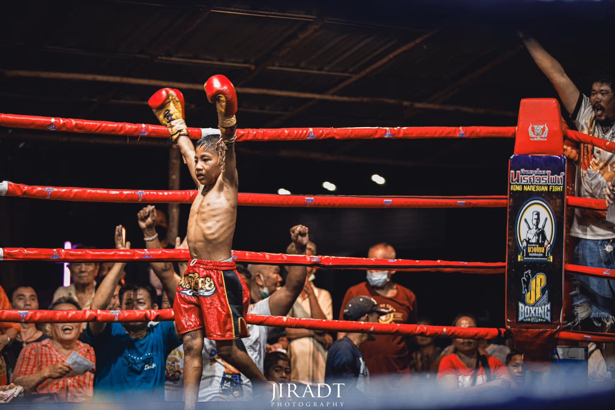 Young Muay Thai winner celebrating in red shorts